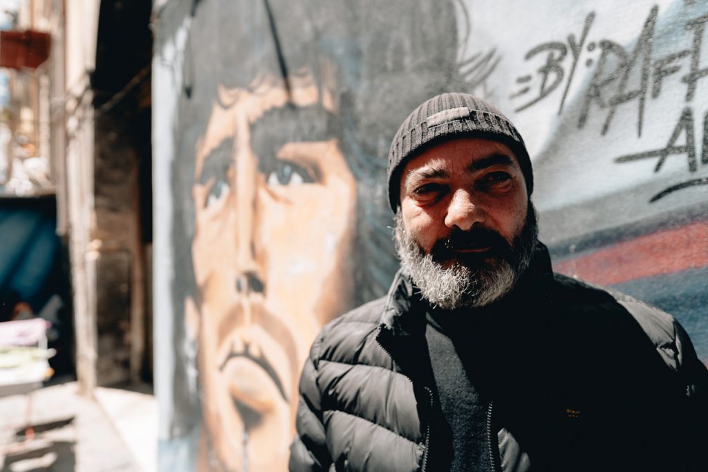 ritratto di uomo a Napoli con sfondo Maradona